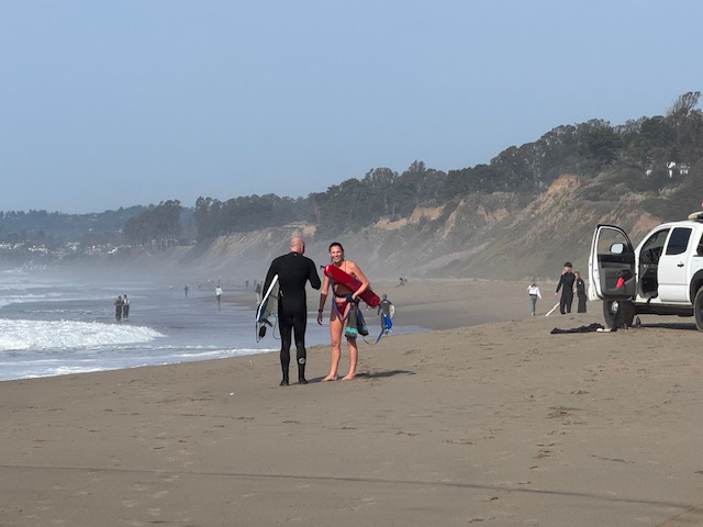 Surfer, lifeguard rescue young bodyboarder from pounding surf at Santa Cruz County beach
